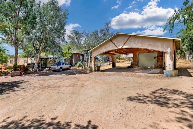 view of front facade with a carport, driveway, and stucco siding