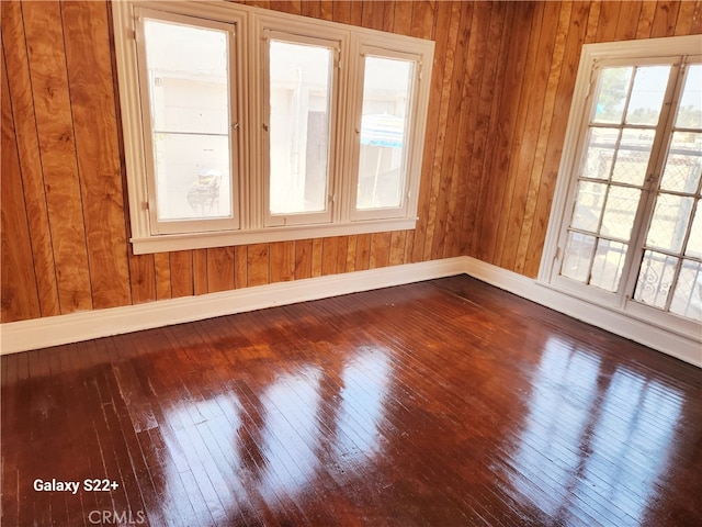 spare room with wood walls and hardwood / wood-style flooring