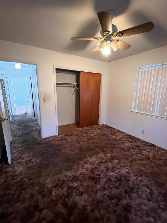 unfurnished bedroom featuring ceiling fan, carpet flooring, and a closet