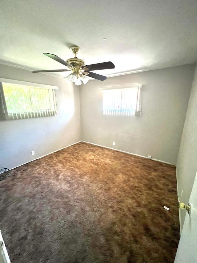 empty room featuring ceiling fan, plenty of natural light, and carpet