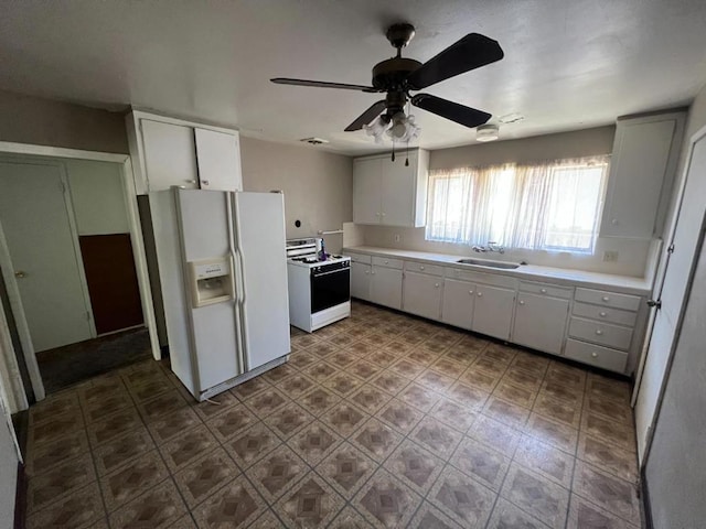 kitchen featuring white appliances, ceiling fan, sink, dark tile patterned floors, and white cabinetry