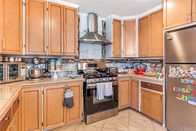 kitchen featuring light tile flooring, tasteful backsplash, stainless steel appliances, and wall chimney exhaust hood