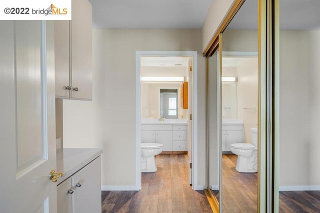 bathroom with hardwood / wood-style floors, vanity, and toilet