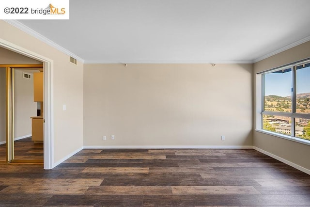 spare room with dark hardwood / wood-style floors and ornamental molding