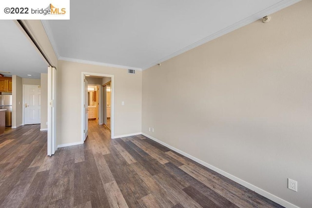 unfurnished room featuring ornamental molding and dark wood-type flooring