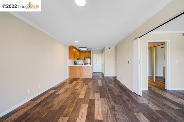 unfurnished living room featuring ornamental molding and dark wood-type flooring