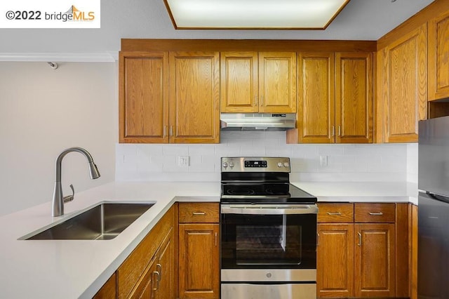 kitchen featuring decorative backsplash, appliances with stainless steel finishes, crown molding, and sink