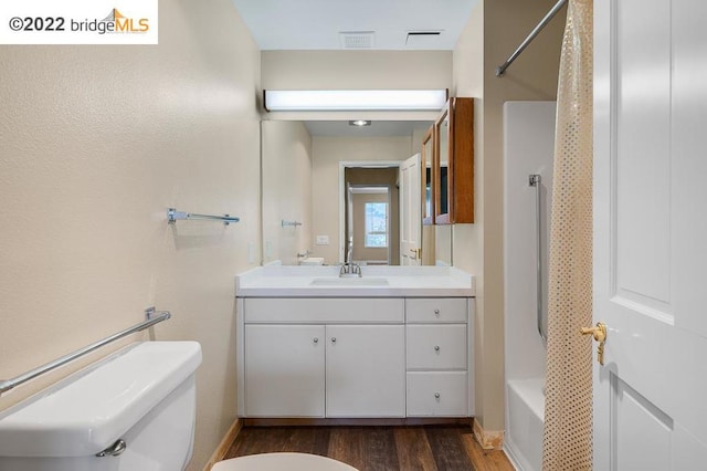 full bathroom with hardwood / wood-style flooring, vanity, toilet, and washtub / shower combination