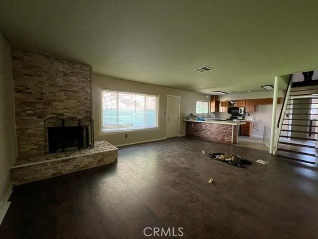 unfurnished living room with a stone fireplace