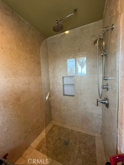 bathroom with tile patterned floors and tiled shower