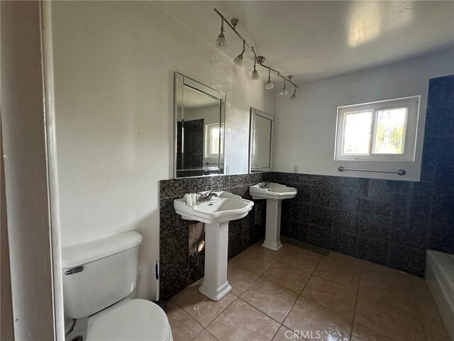 bathroom with tile walls, toilet, and tile patterned flooring