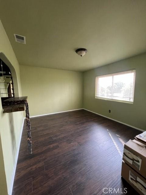 living area featuring dark wood-style floors, baseboards, and visible vents