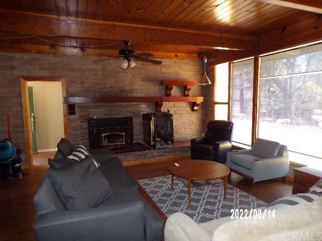 13425 Jensen Rd, Clearlake Oaks, CA 95423 - living room featuring wooden ceiling, ceiling fan, hardwood / wood-style floors, a fireplace, and beam ceiling