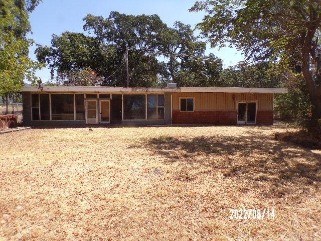 back of house with a sunroom and a lawn