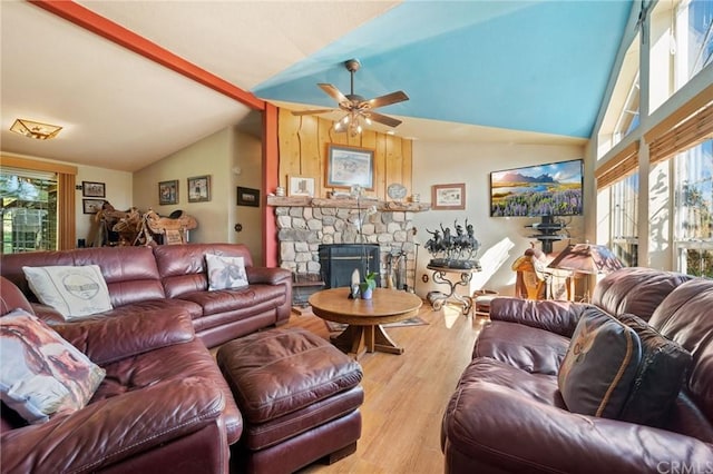 living room with lofted ceiling, light hardwood / wood-style floors, ceiling fan, and a fireplace