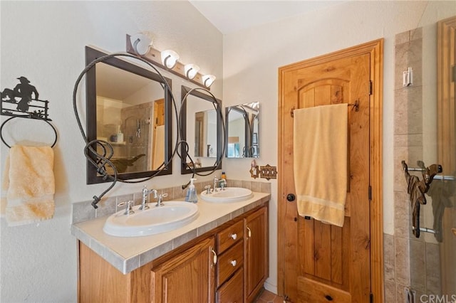 bathroom with an enclosed shower and dual vanity