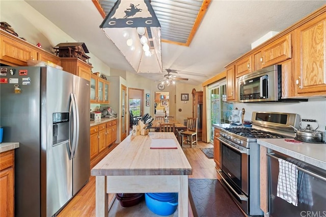 kitchen featuring stainless steel appliances, ceiling fan, and light wood-type flooring