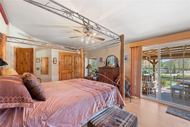 bedroom with access to outside, lofted ceiling, light hardwood / wood-style floors, and ceiling fan