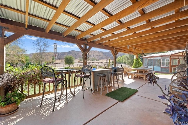 view of patio with a bar, a pergola, and a mountain view