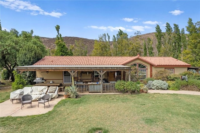 view of front of house featuring a front yard, a patio area, and a mountain view