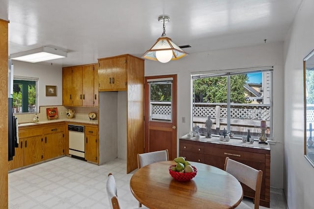 kitchen with backsplash, hanging light fixtures, light tile floors, and dishwasher