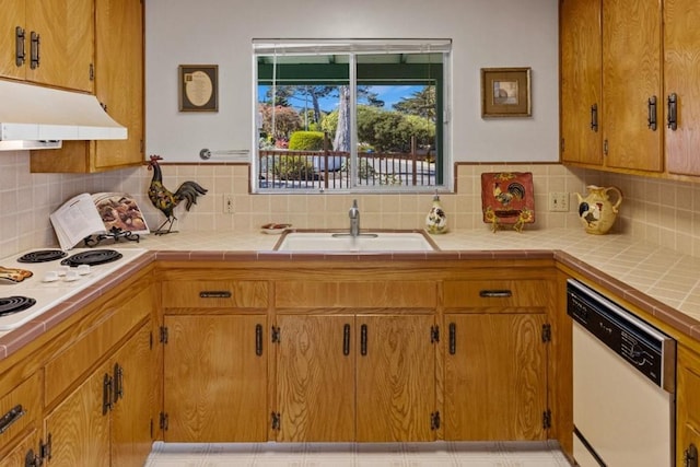 kitchen with white dishwasher, tile countertops, tasteful backsplash, and sink