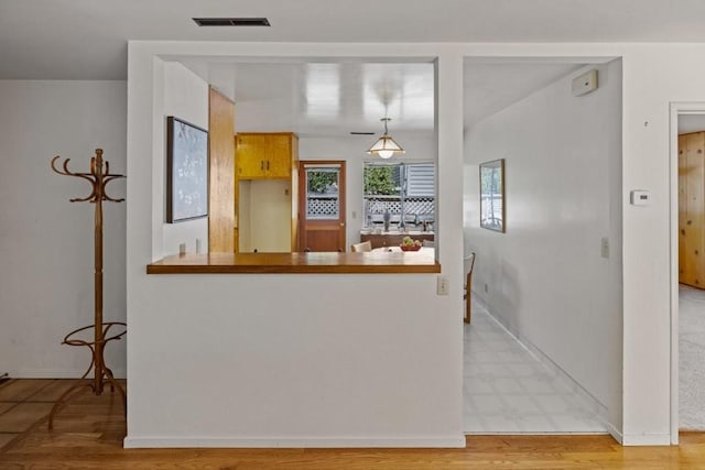 kitchen featuring hanging light fixtures and light hardwood / wood-style flooring