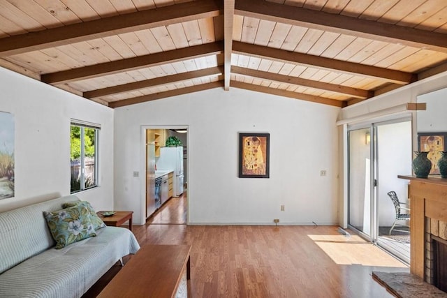 living room featuring lofted ceiling with beams, light hardwood / wood-style floors, wood ceiling, and a fireplace