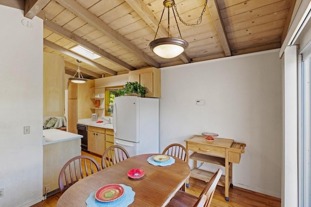 dining space with wood ceiling, light wood-type flooring, sink, and beamed ceiling