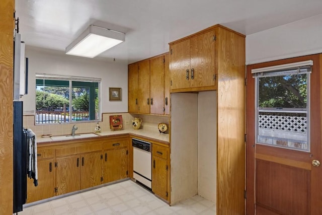 kitchen featuring sink, a healthy amount of sunlight, dishwasher, and light tile flooring