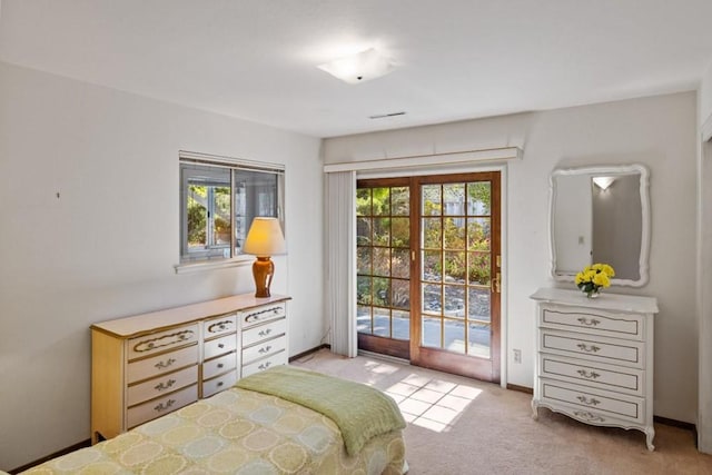 bedroom with access to exterior and light colored carpet