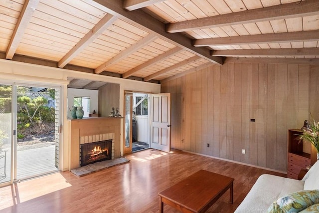 living room with wooden walls, wood-type flooring, wooden ceiling, and lofted ceiling with beams