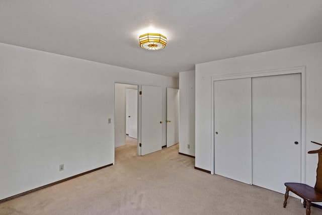 unfurnished bedroom with light carpet and a closet