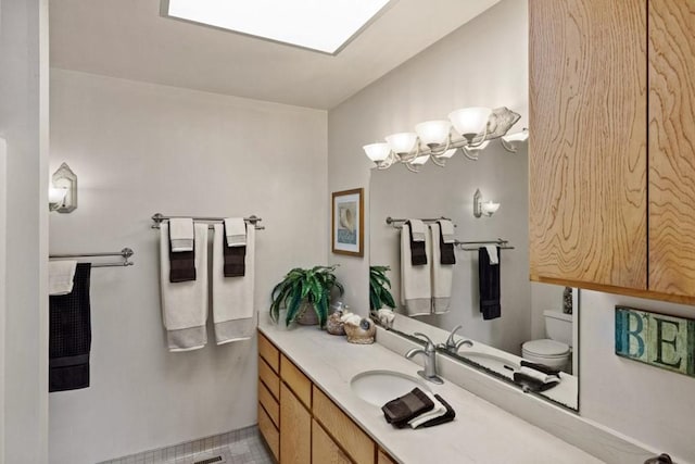 bathroom featuring toilet, tile flooring, and vanity