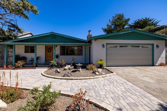 single story home with covered porch and a garage