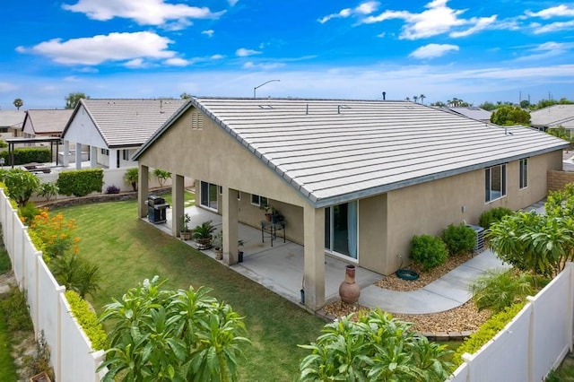 back of house with a lawn and a patio