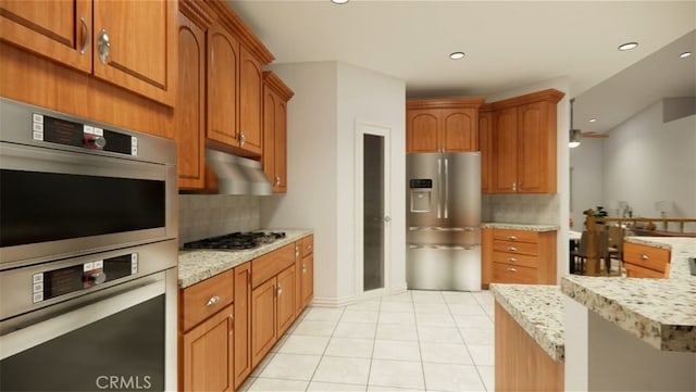 kitchen featuring stainless steel appliances, light tile patterned flooring, light stone countertops, and tasteful backsplash