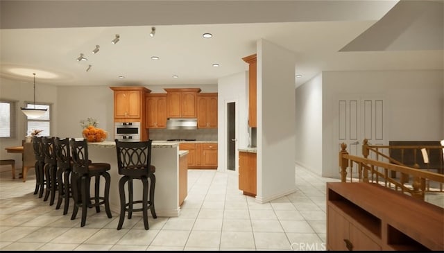 kitchen featuring tasteful backsplash, light tile patterned floors, oven, and a breakfast bar