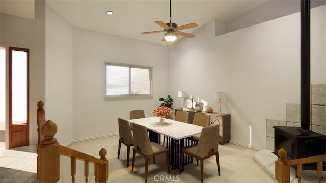 carpeted dining space with vaulted ceiling, a wood stove, and ceiling fan