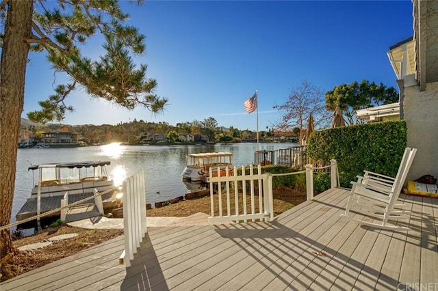 wooden terrace featuring a water view and a boat dock