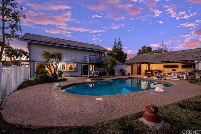 pool at dusk featuring a patio