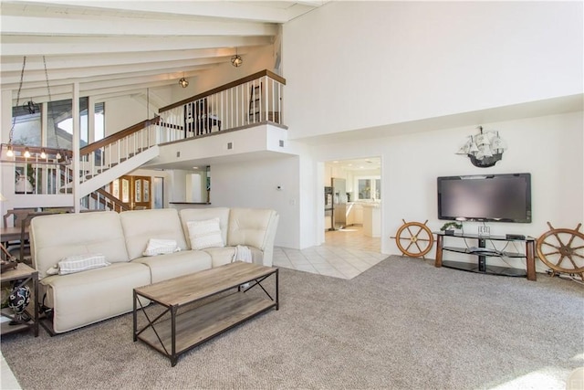 carpeted living room with beam ceiling and high vaulted ceiling