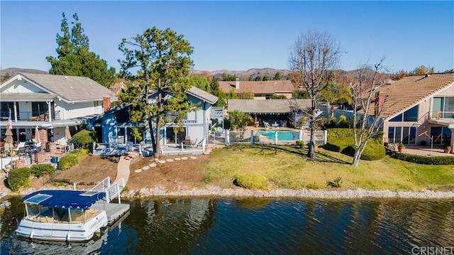 rear view of property featuring a lawn and a water view