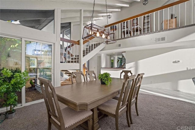 carpeted dining room featuring a chandelier, high vaulted ceiling, and beamed ceiling