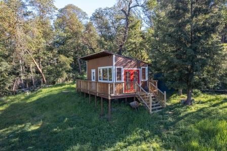 rear view of house with a wooden deck and a yard