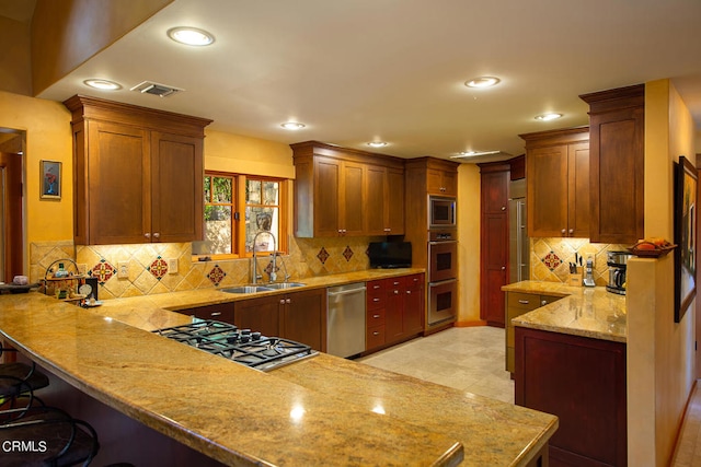 kitchen with a kitchen breakfast bar, kitchen peninsula, tasteful backsplash, and light stone counters