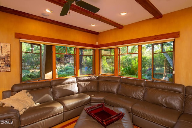 living room featuring ceiling fan, beam ceiling, and a wealth of natural light