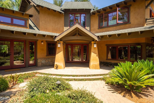 view of exterior entry with a patio area and french doors