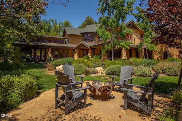 exterior space featuring an outdoor fire pit, a front lawn, and a patio area