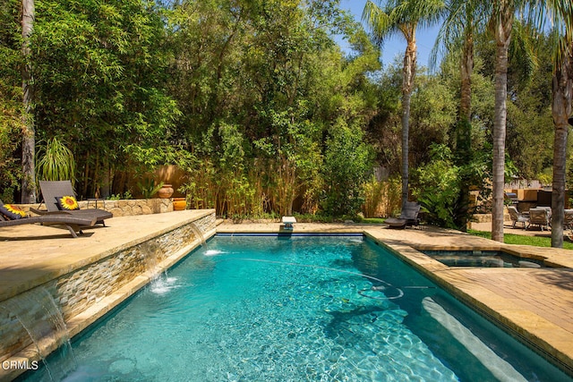 view of swimming pool with pool water feature and a patio area